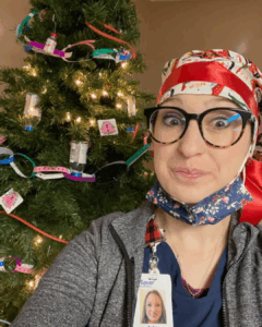 Nurse standing in fromt of a christmas tree during the holidays